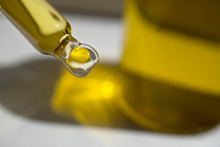 A drop of cosmetic aromatic oil drips from the pipette. Front view.の写真素材
