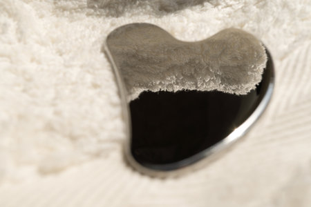 Stainless steel gua sha tool with soft towel, close-upの写真素材
