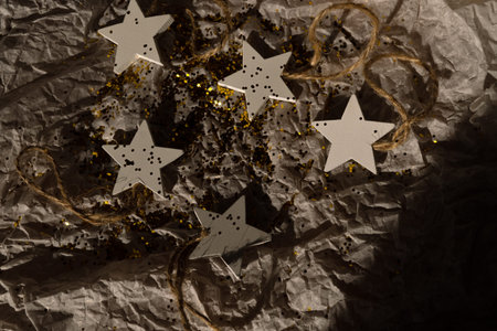 Festive background. There is glitter and Christmas tree decorations on the wrapping paper.