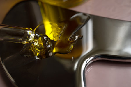 pipette with oil lies on a metal gua sha massagerの写真素材