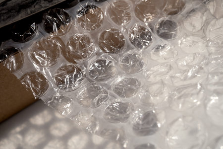 Wrapping an item in textured bubble wrap for shipping. non-ecological packaging of goods for your...