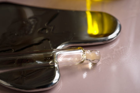 pipette with oil lies on a metal gua sha massagerの写真素材