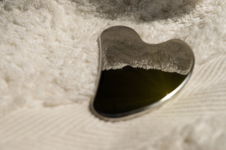 Stainless steel gua sha tool with soft towel, close-upの写真素材
