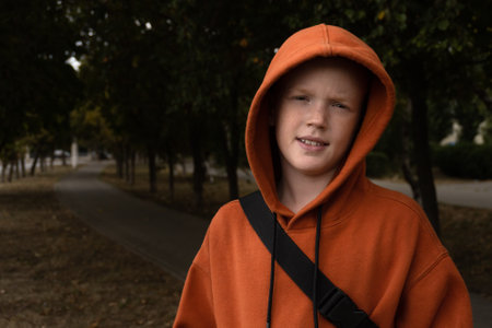 Portrait of a child in a sweatshirt on a city streetの写真素材