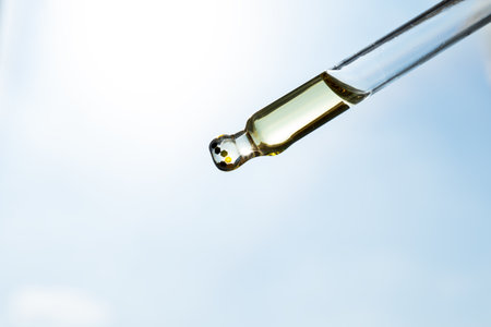 Pipette with essential oil on bottle blurred backgroundの写真素材