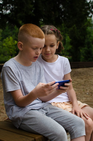 A boy and a girl walk on scooters and communicate