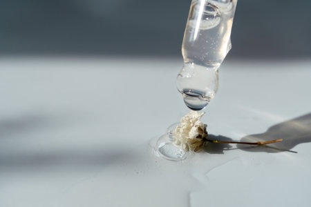 Pipettes with a cosmetic product and flowers on a blue backgroundの写真素材