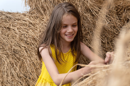 Portrait of a happy girl near haystacksの写真素材