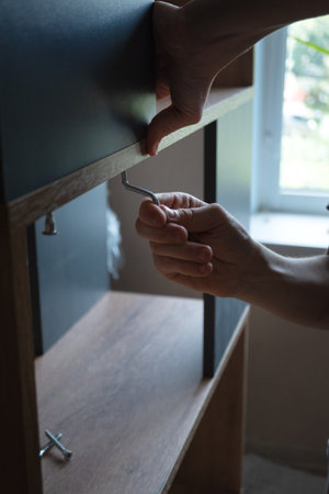 Hands screwing a furniture screw into a grooveの写真素材