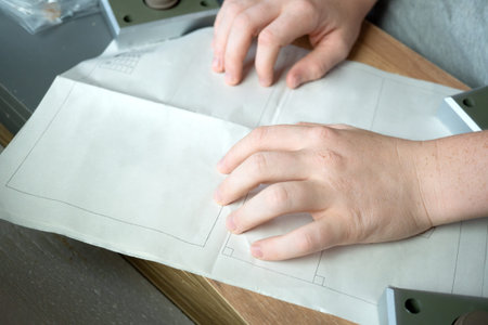 Cropped hand of a child assembling furniture according to instructions, using different tools....