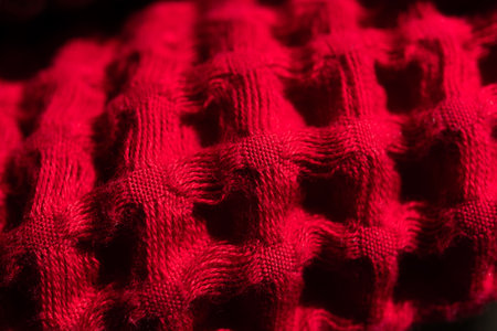 Cotton waffle towel background in soft red color, fabric background. Waffle bath or beach towels. Macro. Slow motion.の写真素材