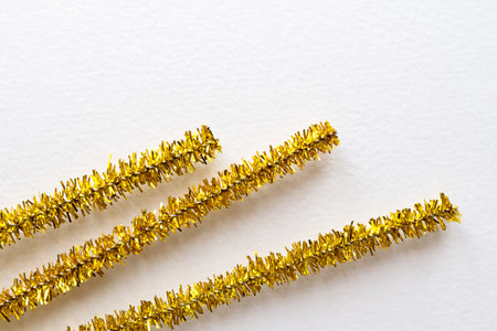 Gold decorative tinsel for crafts. Background image with golden tinsel for creativity