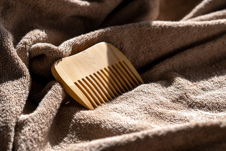a wooden comb lies on a terry towel.の写真素材