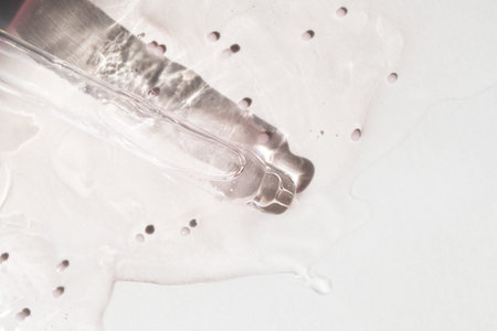 Pipette with essential oil on bottle blurred background