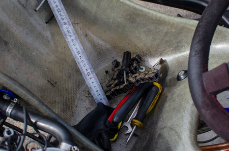 Tape measure, wrench, screwdriver and chain in the seat of a racing carの写真素材
