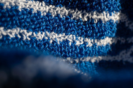 Blue cotton terry towel with white stripes, fabric background. Terry bath or beach towels. Macro.
