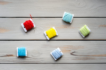 Preparation for embroidery, a set of threads on spools on a wooden surfaceの写真素材
