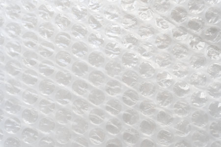 Wrapping an item in textured bubble wrap for shipping. non-ecological packaging of goods for your...