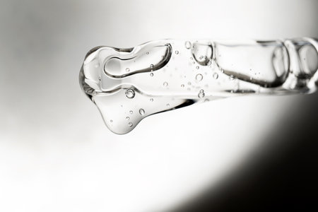 A drop of cosmetic aromatic oil drips from the pipette. Front view.の写真素材