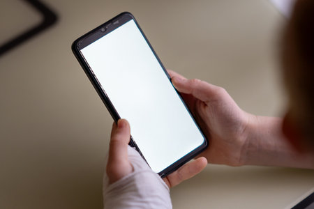 Crop hand of a child in a white plaster cast and bandage holding a phoneの写真素材