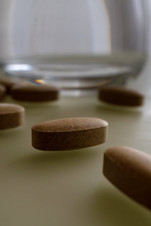 A glass of water and tablets on the table. Lifestyle. Close-up