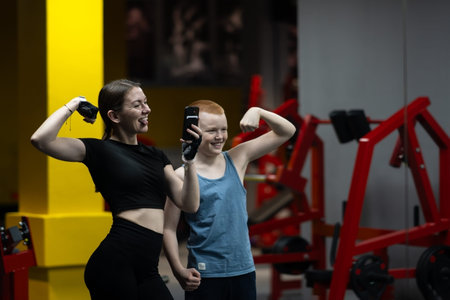 Portrait of young woman and teenager using phone and taking selfie photo while taking break during...
