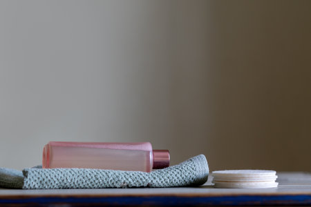 Natural cosmetic product for facial care and spa treatments. A bottle of facial emulsion and cotton reusable pads on the surfaceの写真素材