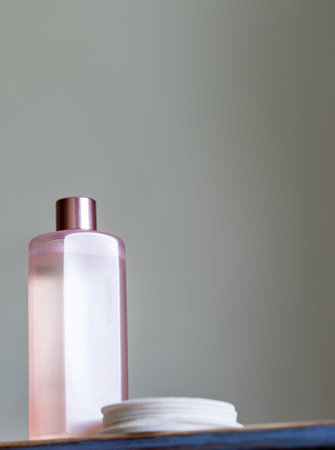 Natural cosmetic product for facial care and spa treatments. A bottle of facial emulsion and cotton reusable pads on the surfaceの写真素材