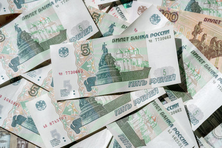 Money is scattered on the surface. Close-up of denominations of five and a hundred Russian rublesの写真素材