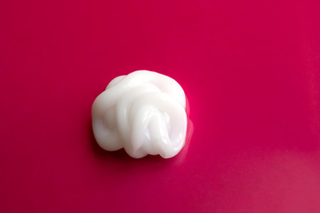 cosmetic smears cream texture on a red backgroundの写真素材