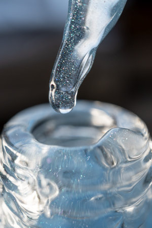 Glass pipette with facial serum on a light background. Essential oil close-up in a pipette. A skin...