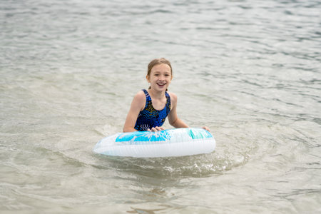 Happy girl playing in the sea with an inflatable ring. Summer seaside vacationの写真素材