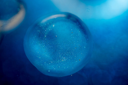 surface of oil or serum with bubbles. festive cosmetic background. Blurred background