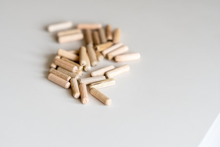 Wooden furniture pegs scattered on the surface of the chipboard. Furniture assembly at homeの写真素材