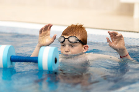 Portrait of a swimmer putting on his goggles in the swimming pool