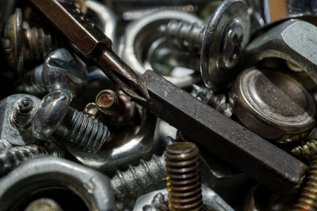 Bolts screws nuts of different sizes close-up. Macrophotography. Texture or background. Selective...