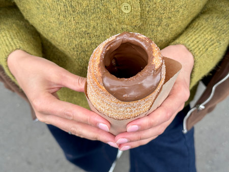 sweet trdelnik with nutella in the hands of a girl in summer. High quality photoの写真素材