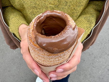 sweet trdelnik with nutella in the hands of a girl in summer. High quality photoの写真素材
