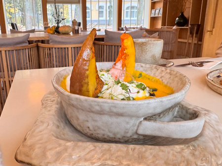 Pumpkin soup with pumpkin seeds, cream and baked pumpkin in the restaurant. High quality photoの写真素材