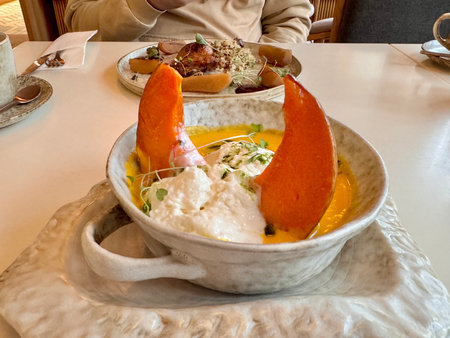 Pumpkin soup with pumpkin seeds, cream and baked pumpkin in the restaurant. High quality photoの写真素材