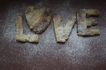 The cookies are made on a red background, sprinkled with flour. Letters from the LOVE test. It can be used in a web design, the menu, the calendar.の写真素材