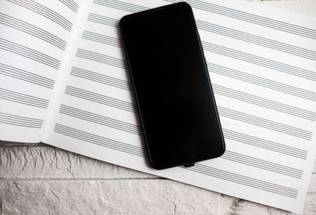 Phone with a music book on a light backgroundの写真素材