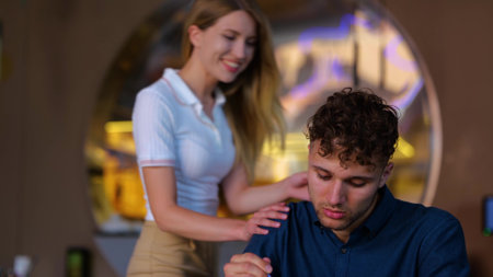 Young beautiful woman closing her boyfriend in restaurant. Dating in a cafe. Lady making surprise for her boyfriend. Love, dating, food, lifestyle concept. Real timeの写真素材
