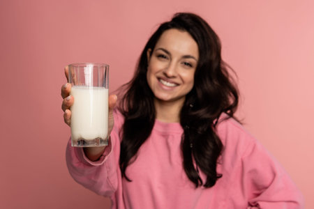 Smiling friendly dark-haired cute young woman showing in front of the camera her favorite dairy...