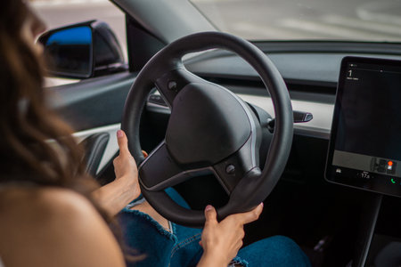 Young woman hands on the steering wheel of a car. Summer trip. Cropped. Travel, lifestyle, transport conceptの写真素材