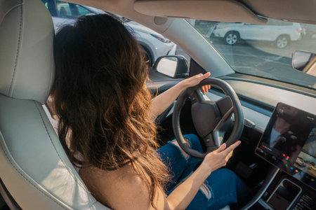 Young woman holding the steering wheel with her hands while driving on summer weekend. Travel...