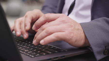 Man using laptop and headset while sitting in the city. Slow motion