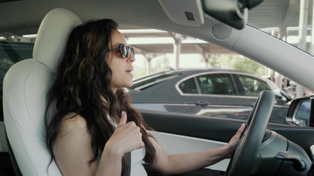Smiling woman driving in the city and singing a song. Trip concept.