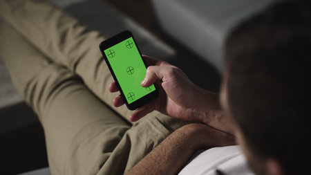 Man holding smartphone with chroma key mock up green screen. Slow motion