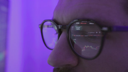 Man in eyeglasses watching stock trading market financial data growth conceptの写真素材